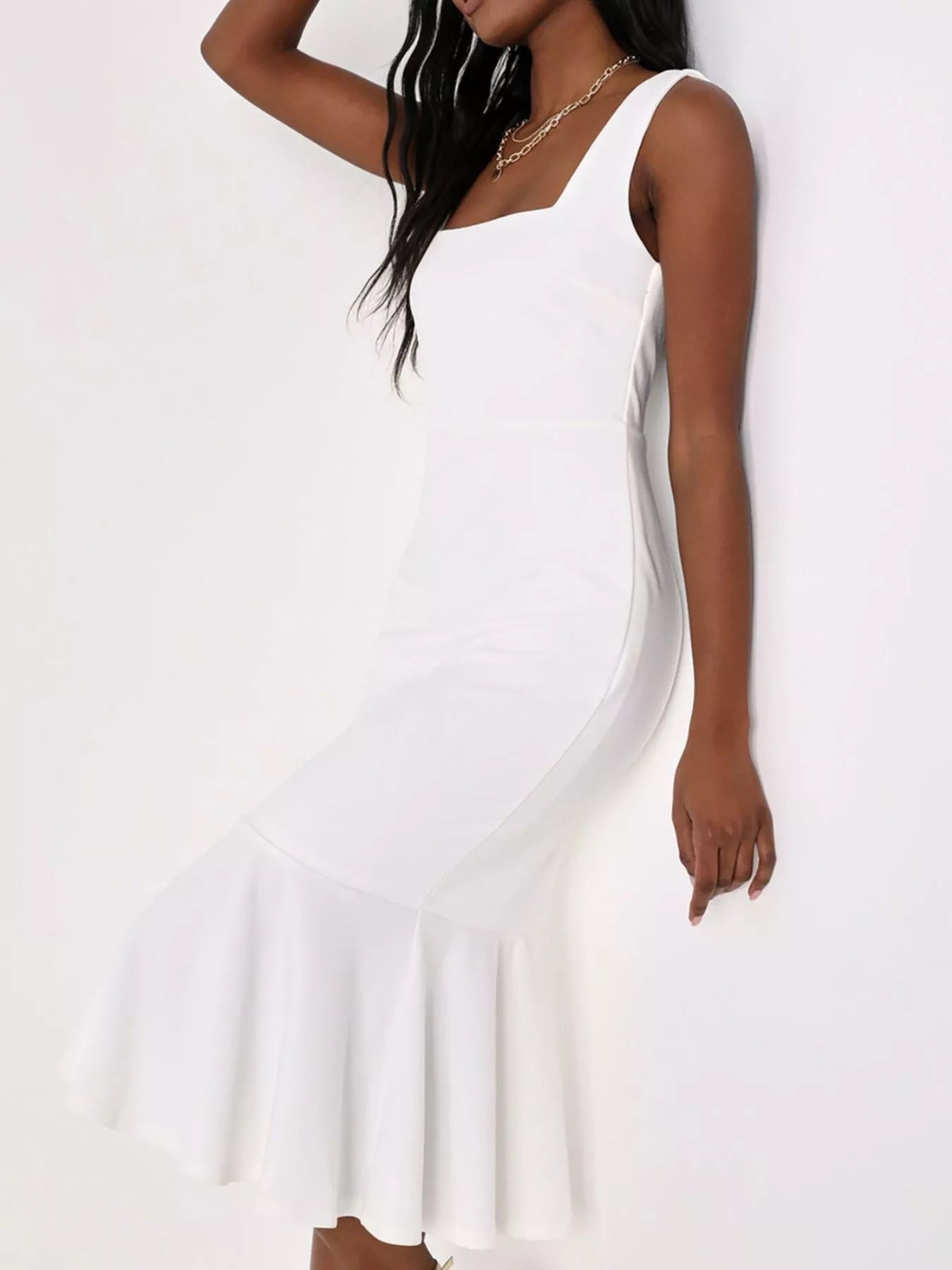 NEWYORKLISTED STYLE COLLECTION: A woman wearing a white sleeveless midi dress with a square neckline, fitted silhouette, and flared ruffled hem, posed against a plain white background.