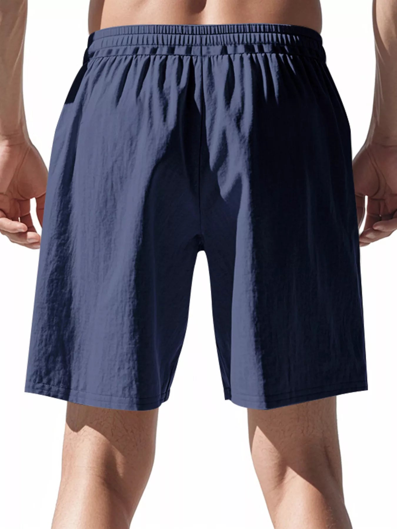 Navy blue shorts worn by a person on a white background
