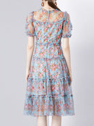 NEWYORKLISTED STYLE COLLECTION: Woman wearing a floral dress on a plain background