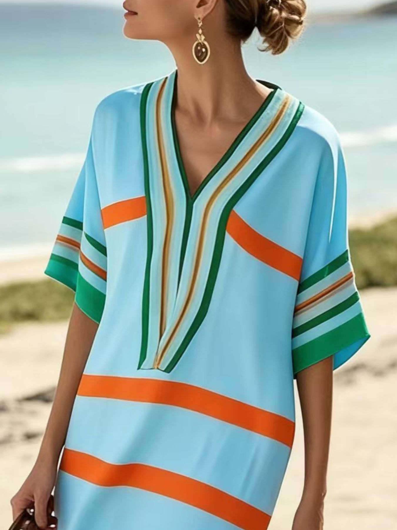 NEWYORKLISTED STYLE COLLECTION: Woman wearing a colorful striped dress on a beach