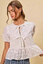 NEWYORKLISTED STYLE COLLECTION:  Woman wearing a white lace top with a beige background