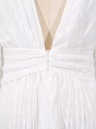 NEWYORKLISTED STYLE COLLECTION: Close-up of a white dress with a deep neckline and bow detail.