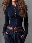NEWYORKLISTED Style Collection: Person wearing a dark blue long-sleeve top with button details and a brown belt against a gray background
