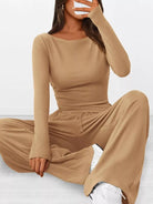 Person wearing a beige long-sleeve top and wide-leg pants on a white background