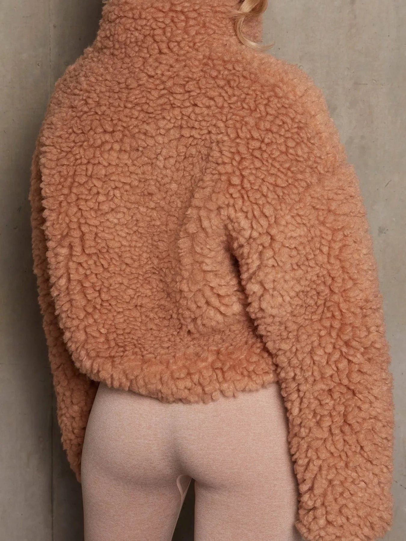 NEWYORKLISTED STYLE COLLECTION: Person wearing a brown sherpa jacket against a neutral background