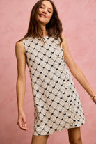 NEWYORKLISTED STYLE COLLECTION: Woman wearing a patterned dress against a pink background
