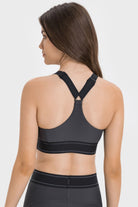 NEWYORKLISTED ACTIVEWEAR COLLECTION: Woman wearing a black sports bra and leggings on a white background