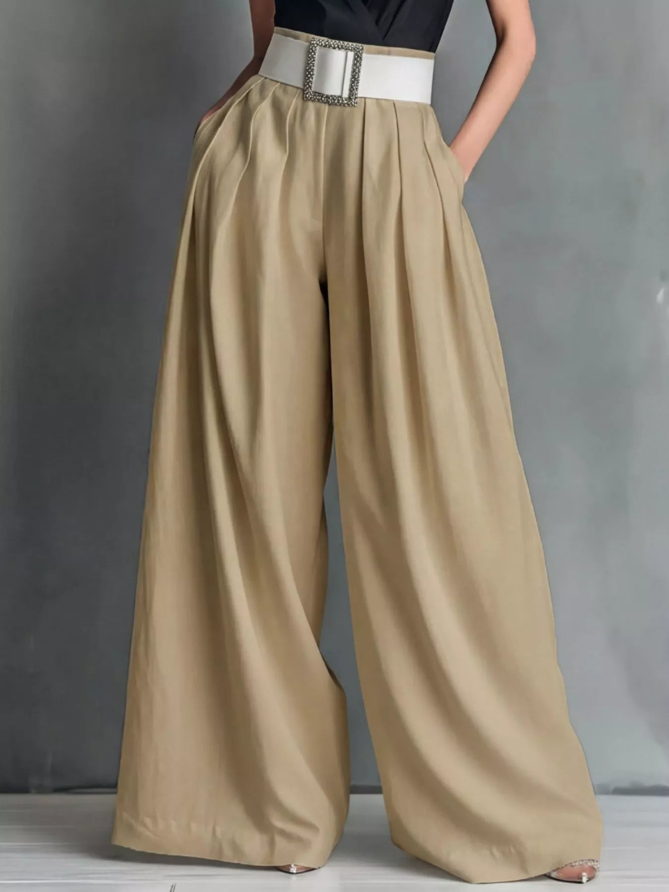 Beige wide-leg pants with a white belt on a gray background