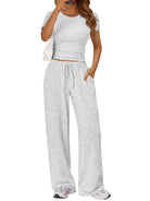 NEWYORKLISTED COMFORT COLLECTION: Woman wearing a gray crop top and wide-leg pants on a white background