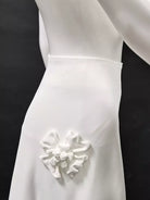 NEWYORKLISTED STYLE COLLECTION: White wedding dress with a decorative flower detail on a black background