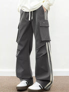 NEWYORKLISTED ATLAS MEN's COLLECTION: Person wearing gray cargo pants with white stripes on a plain background
