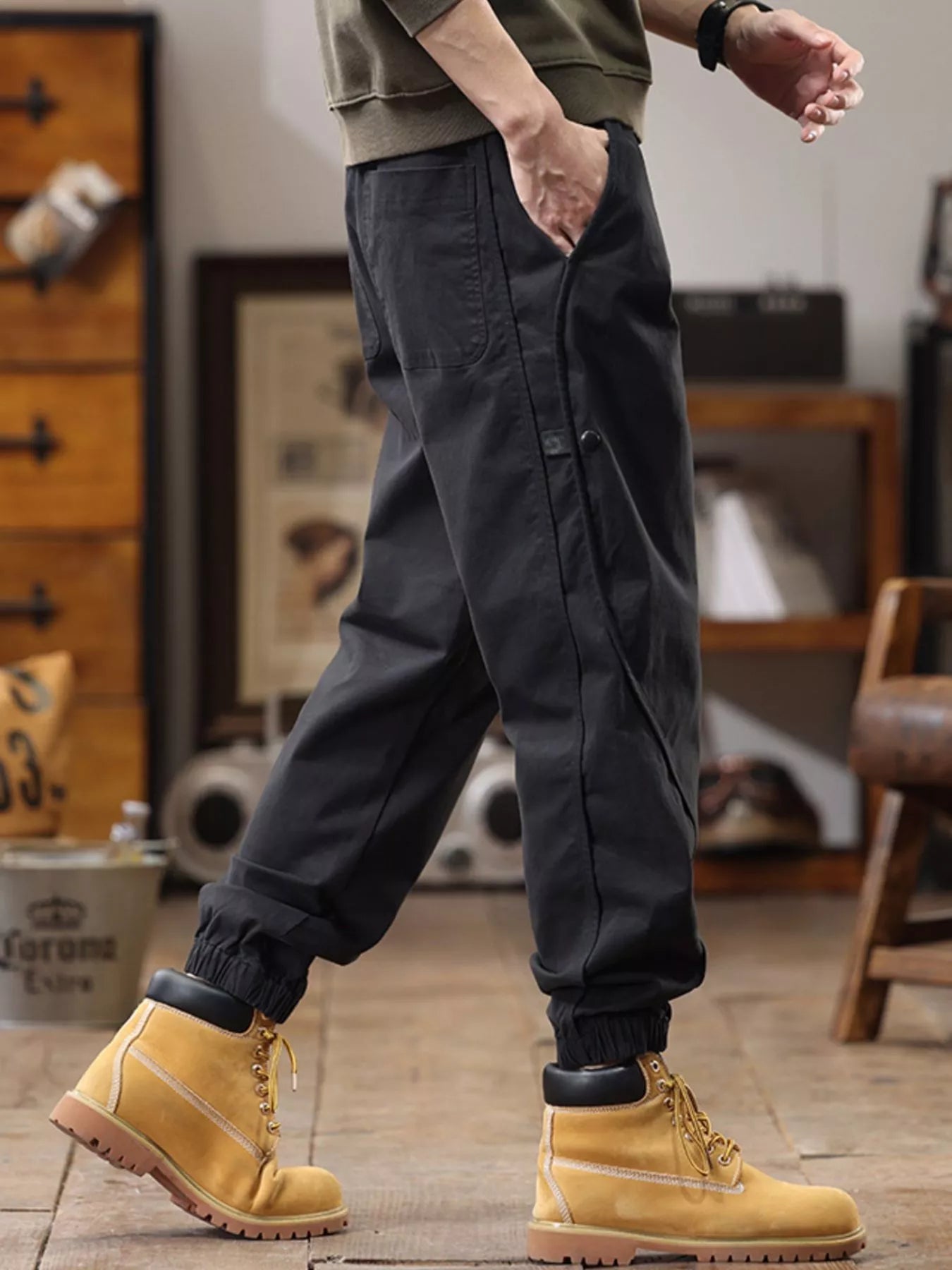 NEWYORKLISTED ATLAS MEN'S COLLECTION: Person wearing dark cargo pants and yellow boots in a casual indoor setting