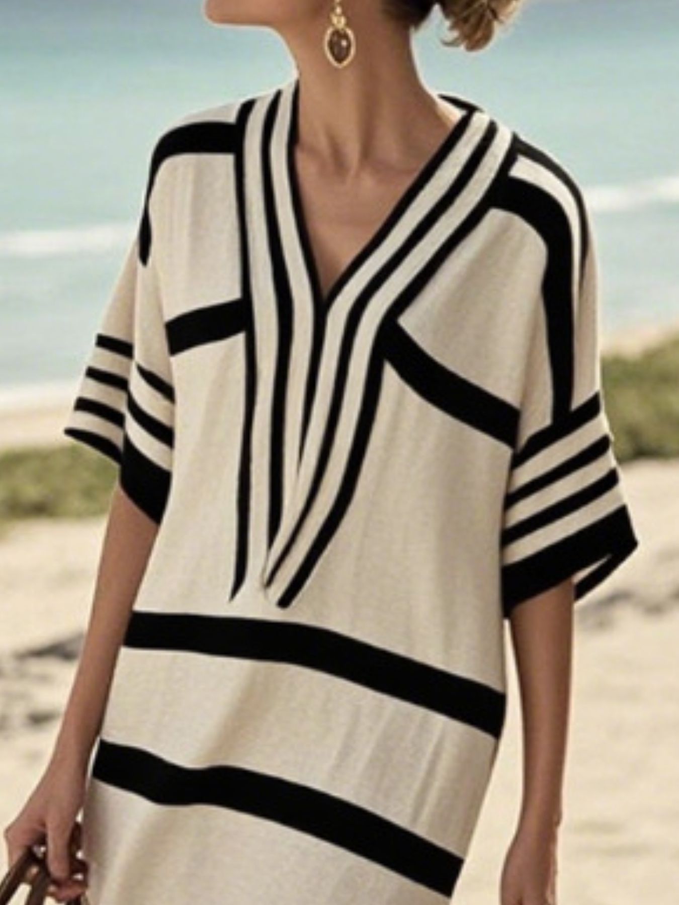 NEWYORKLISTED STYLE COLLECTION: Woman wearing a black and white striped dress on a beach