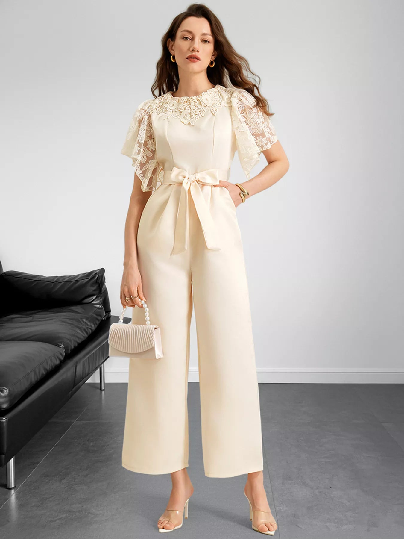 NEWYORKLISTED STYLE COLLECTION: Woman wearing a beige outfit with lace details in a minimalistic room.