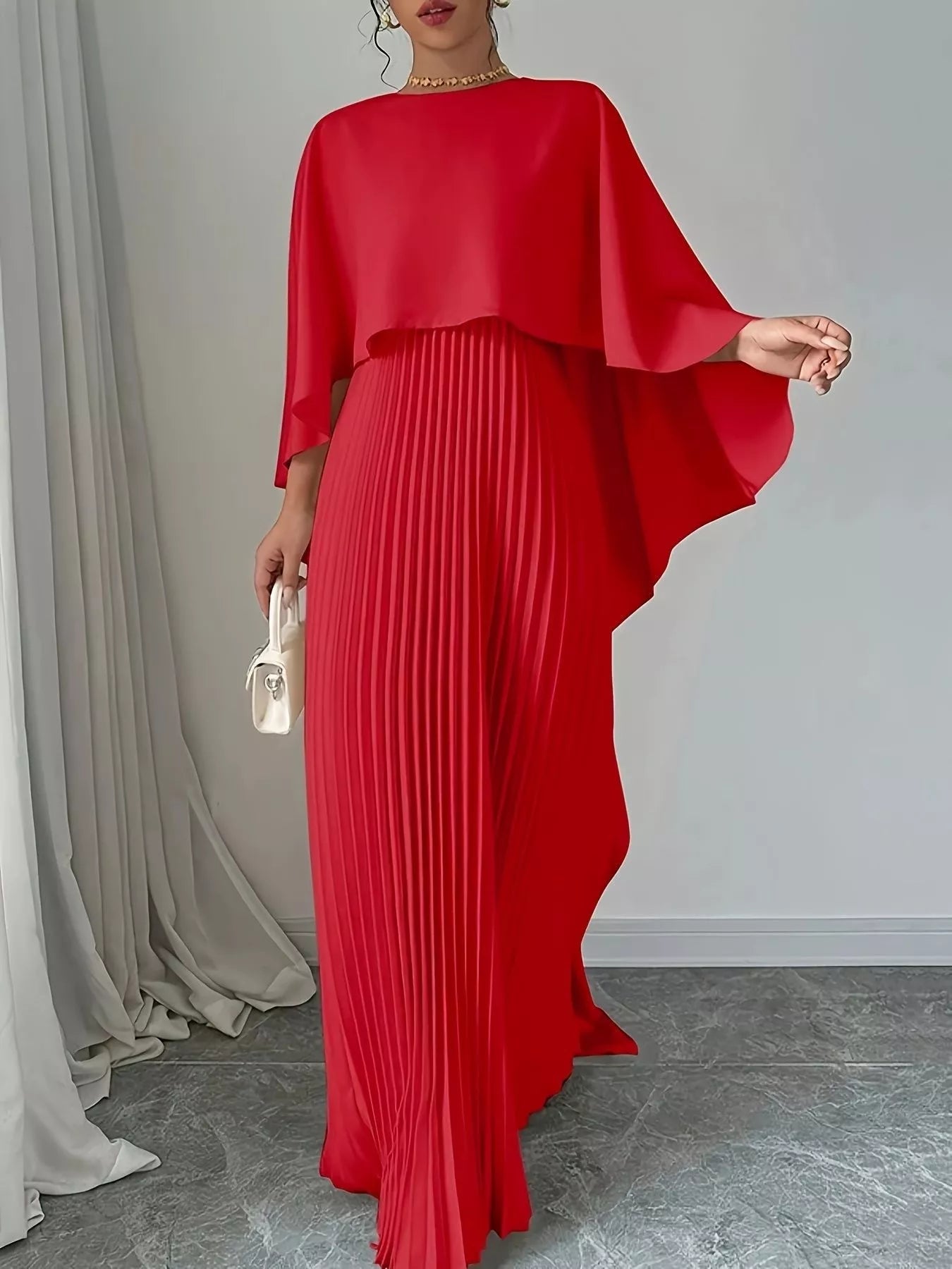 NEWYORKLISTED STYLE COLLECTION: Red pleated dress with cape-like sleeves on a neutral background