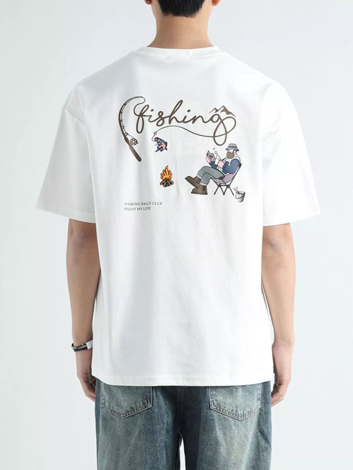 Person wearing a white t-shirt with a fishing-themed graphic on the back.