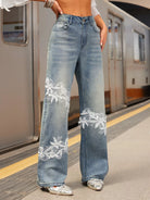NEWYORKLISTED STYLE COLLECTION: Person wearing blue jeans with lace detailing on a subway platform