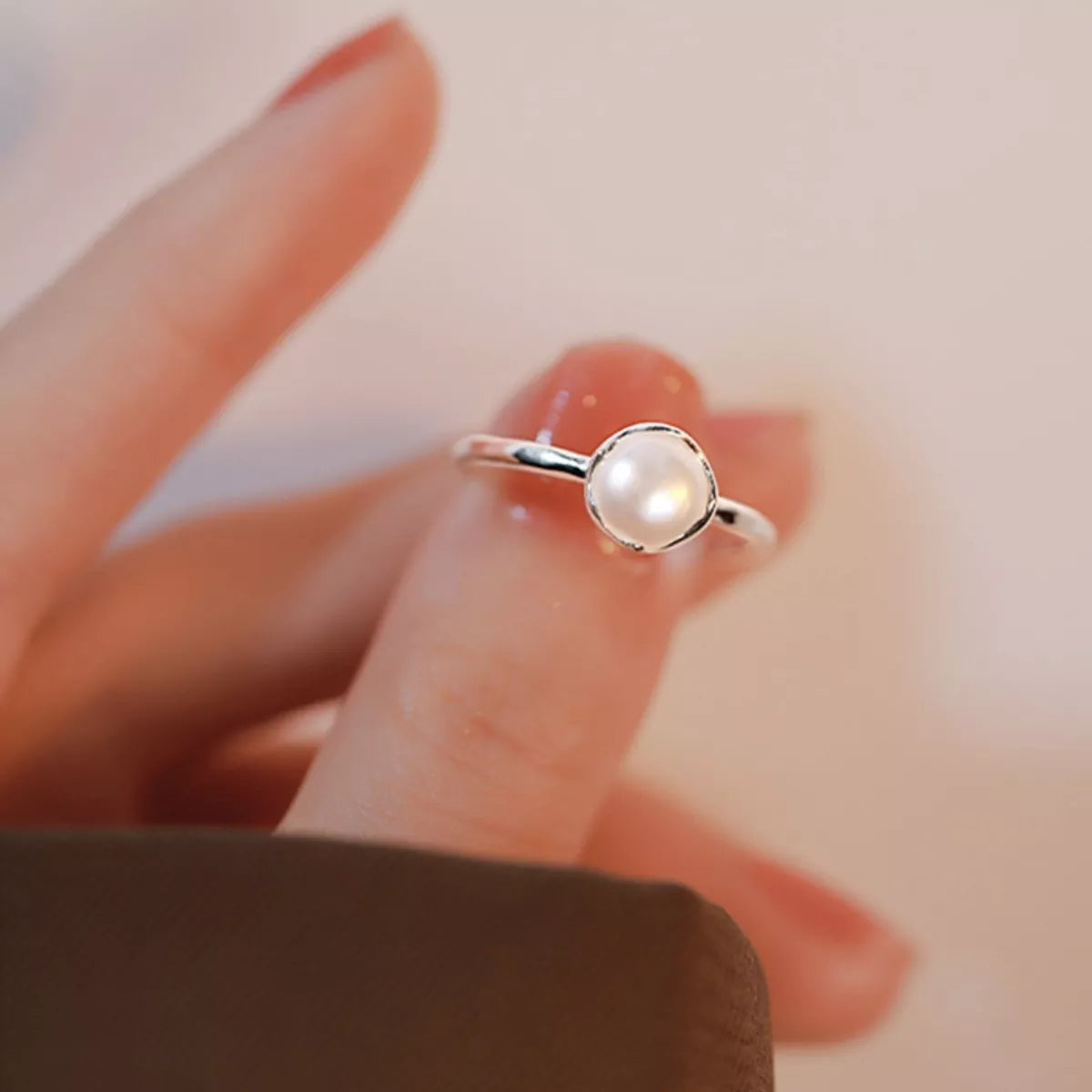 NYLD Glamour By NEWYORKLSITED: Sterling silver ring with freshwater pearl stone on a blurred background
