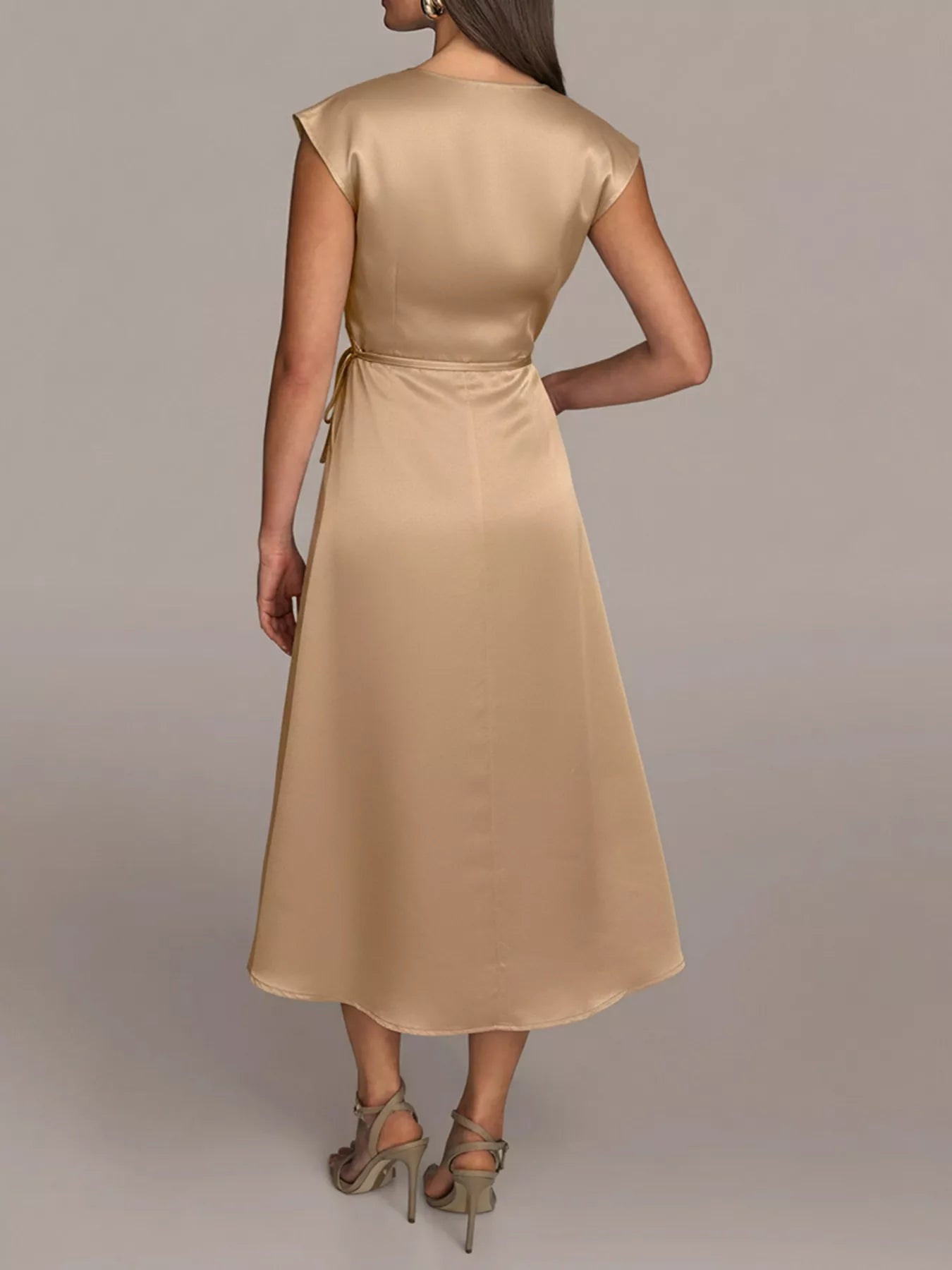 NEWYORKLISTED RUNWAY STYLE: Woman wearing a beige dress against a plain background
