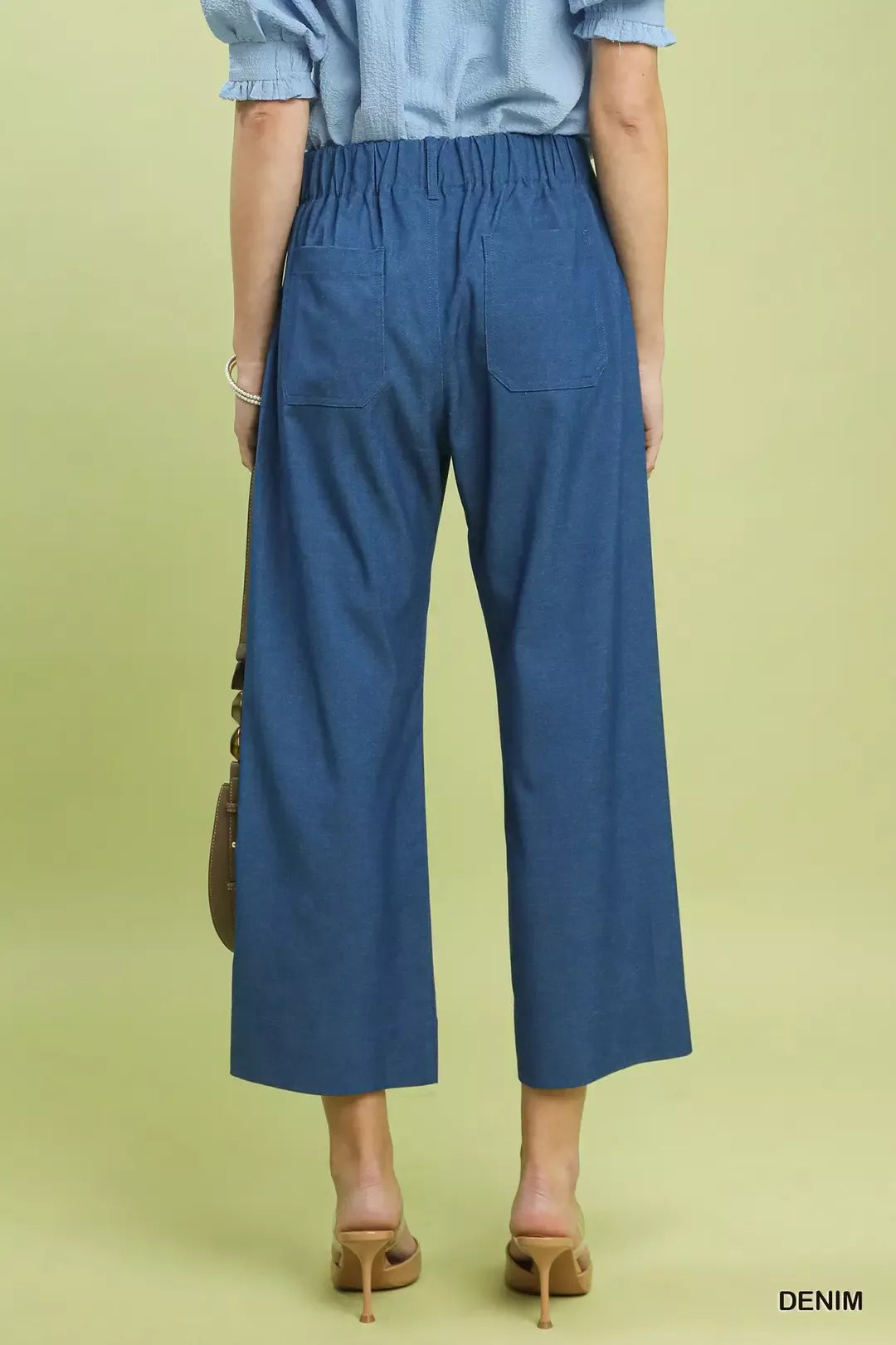 NEWYORKLISTED Style Collection: Person wearing blue denim pants on a light green background