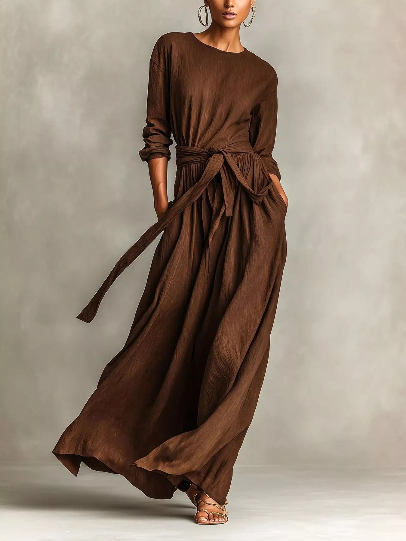 NEWYORKLISTED STYLE COLLECTION: Woman wearing a long brown dress against a neutral background