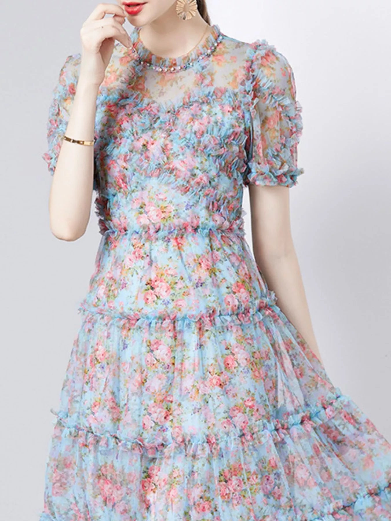 NEWYORKLISTED STYLE COLLECTION: Woman wearing a floral dress with a plain background