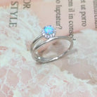 NYLD Glamour Collection by NEWYORKLISTED: Silver ring with a blue gemstone on a textured fabric background