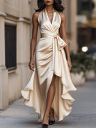 NEWYORKLISTED STYLE COLLECTION: Woman wearing a beige halter neck dress with a bow detail on a city street.