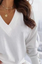 NEWYORKLISTED STYLE COLLECTION: White long-sleeve top worn by a person with gold necklaces.