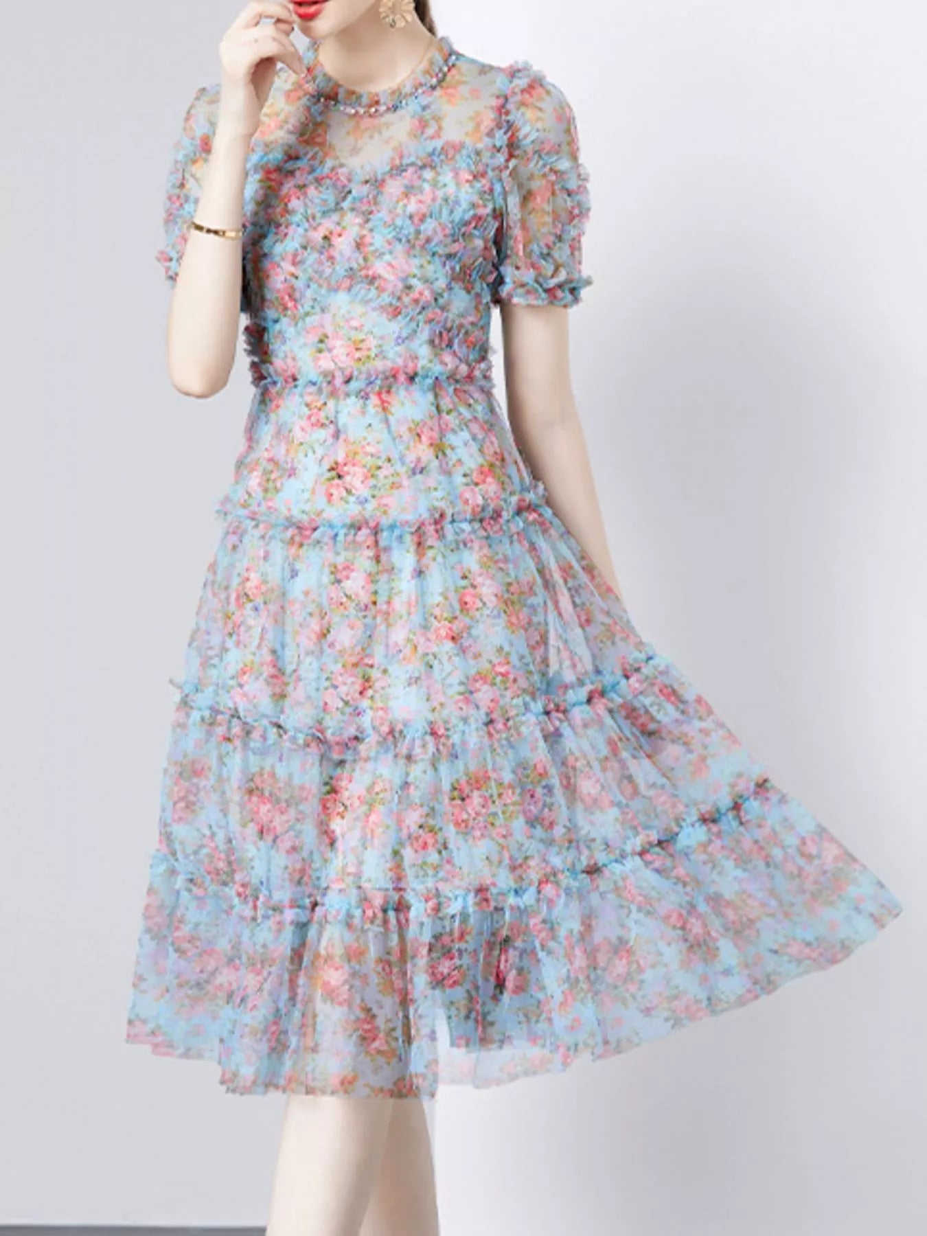 NEWYORKLISTED STYLE COLLECTION: Woman wearing a floral dress on a plain background