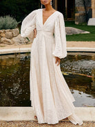 NEWYORKLISTED STYLE COLLECTION: Woman in a white lace dress standing by a pond with greenery in the background