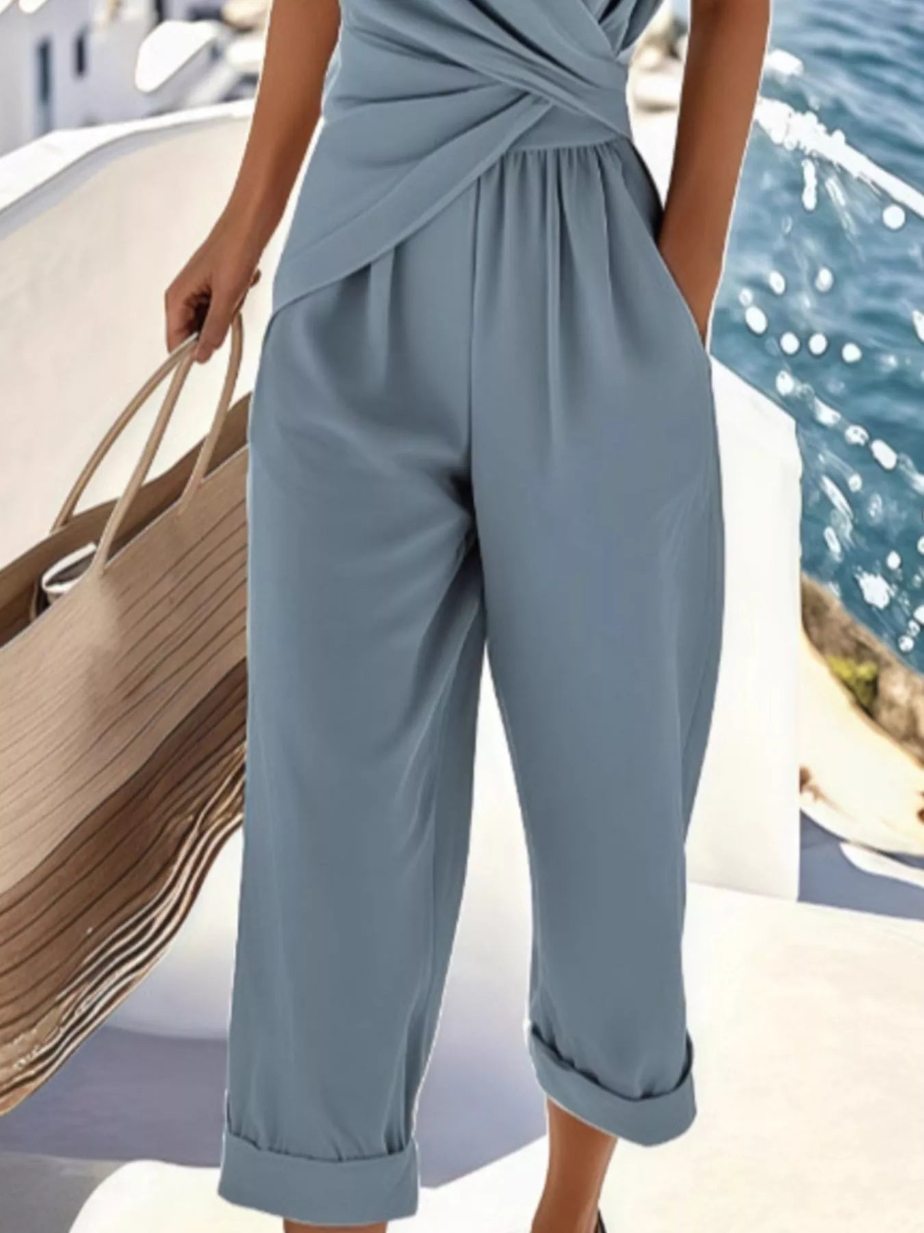 NEWYORKLISTED STYLE COLLECTION: Person wearing a light blue jumpsuit by a waterfront.