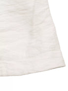 NEWYORKLISTED STYLE COLLECTION: Close-up of a textured white fabric corner on a white background