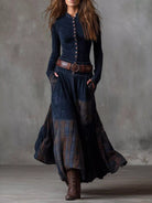NEWYORKLISTED Style Collection: Woman wearing a long, dark blue dress with plaid pattern and brown belt against a gray background