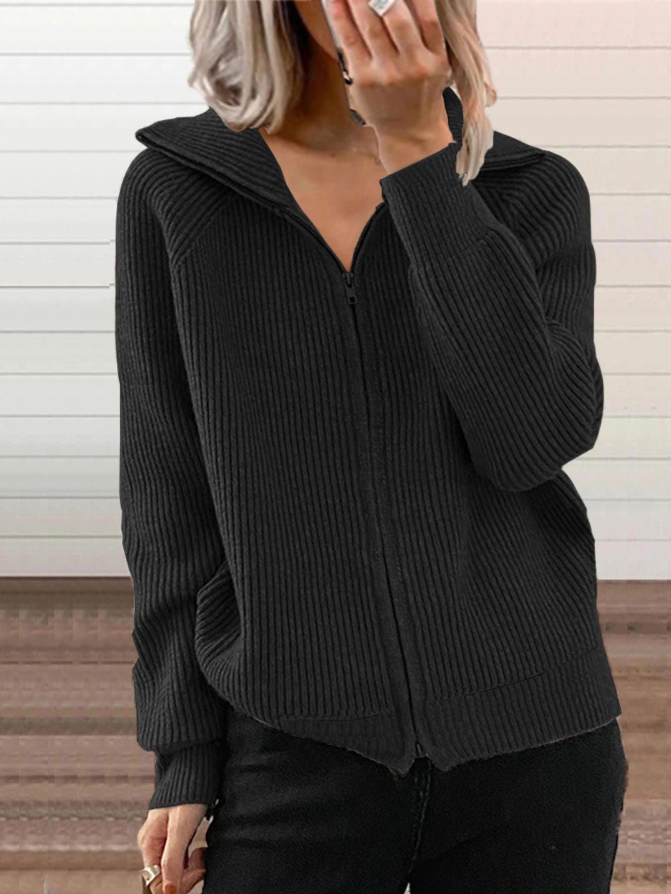 NEWYORKLISTED STYLE COLLECTION: Person wearing a black ribbed sweater against a neutral background
