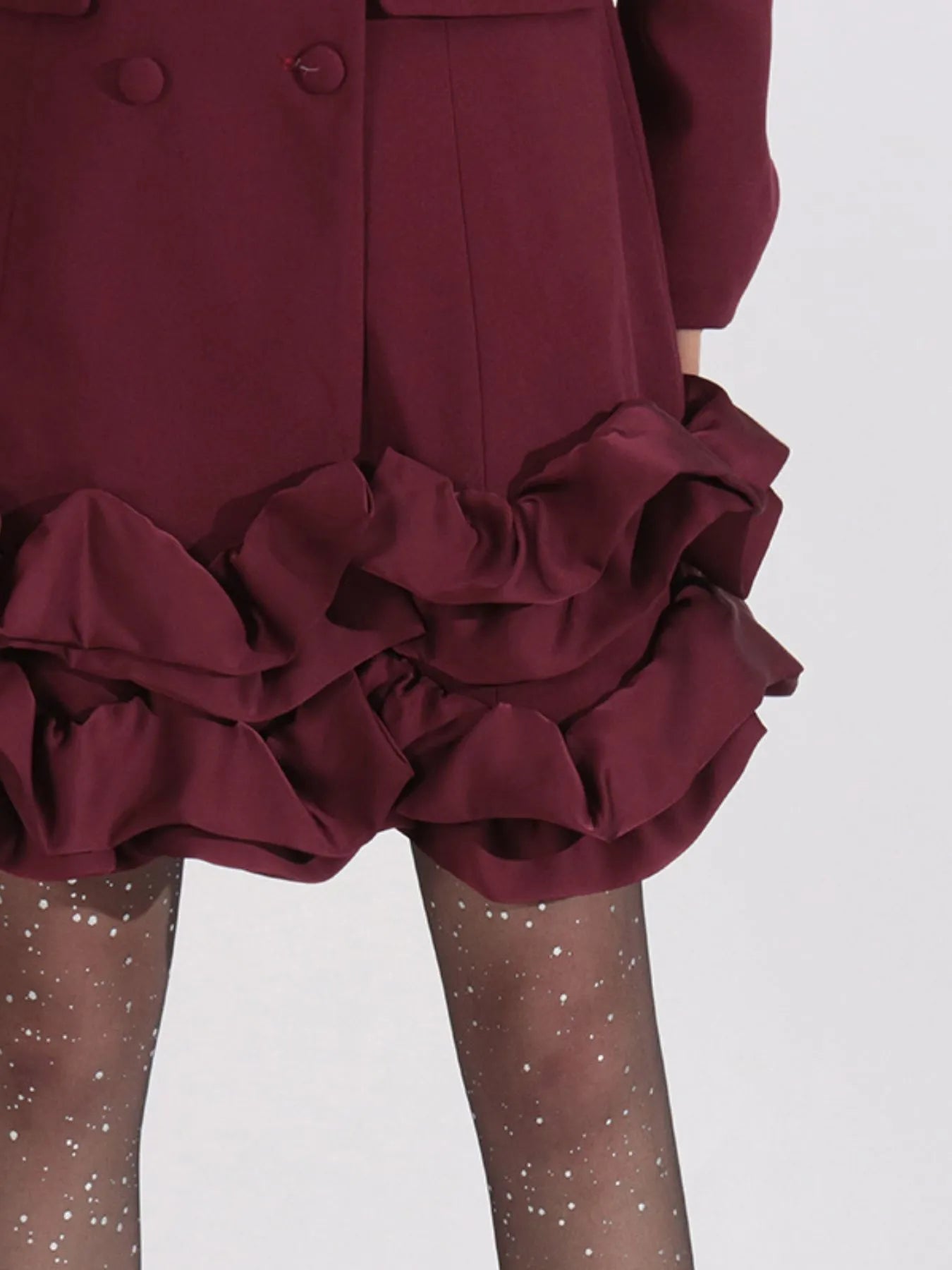 NEWYORKLISTED Runway Style: Maroon coat with ruffled details on a white background