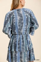 NEWYORKLISTED STYLE COLLECTION: Blue and gray tie-dye dress with puffed sleeves on a beige background