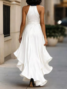 NEWYORKLISTED STYLE COLLECTION: Woman wearing a white halter neck dress walking on a sidewalk.