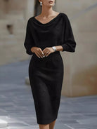 NEWYORKLISTED STYLE COLLECTION: Woman wearing a black dress standing on a street.