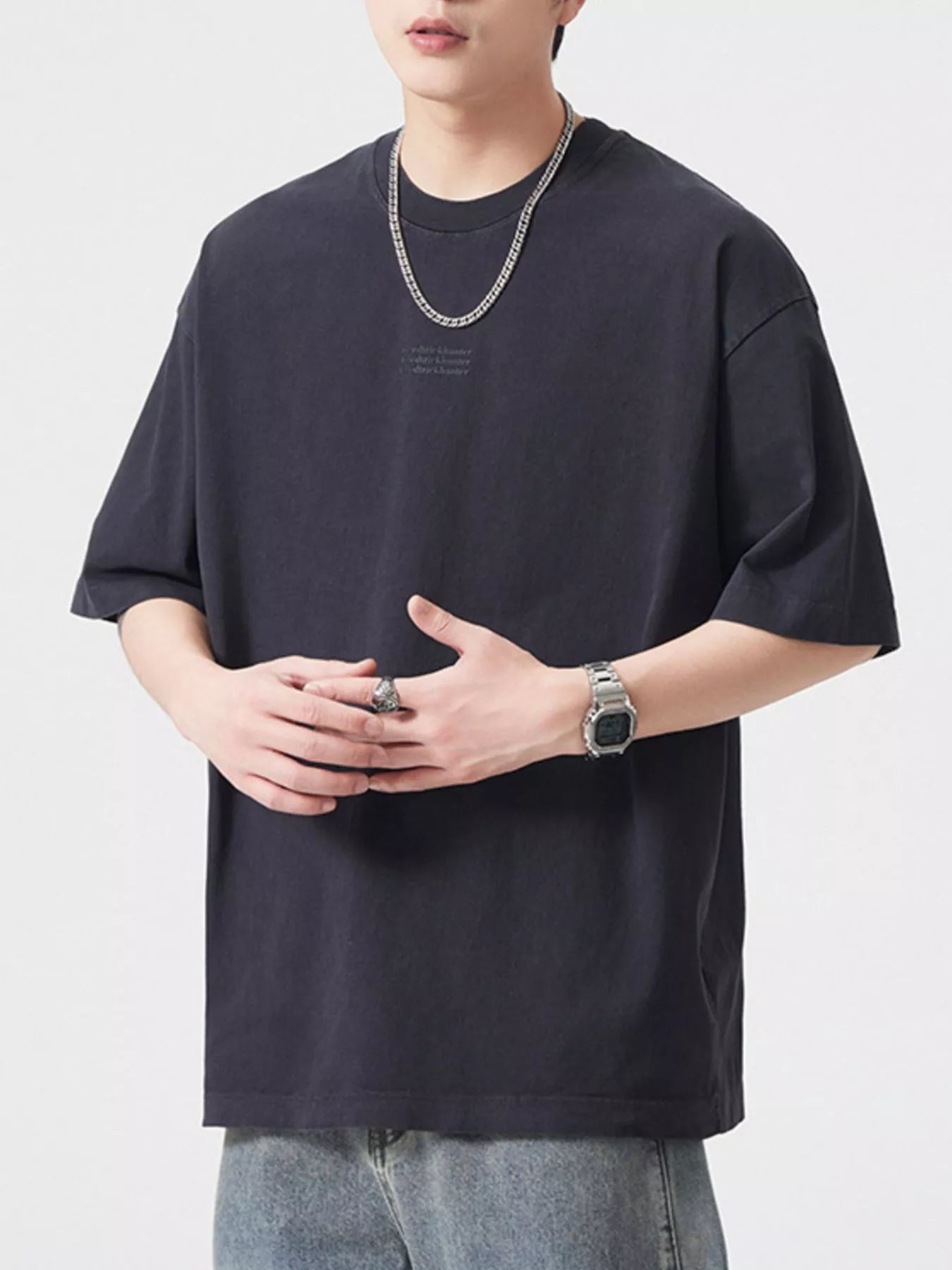 NEWYORKLISTED ATLAS MEN's COLLECTION: Person wearing a black oversized t-shirt with a plain background