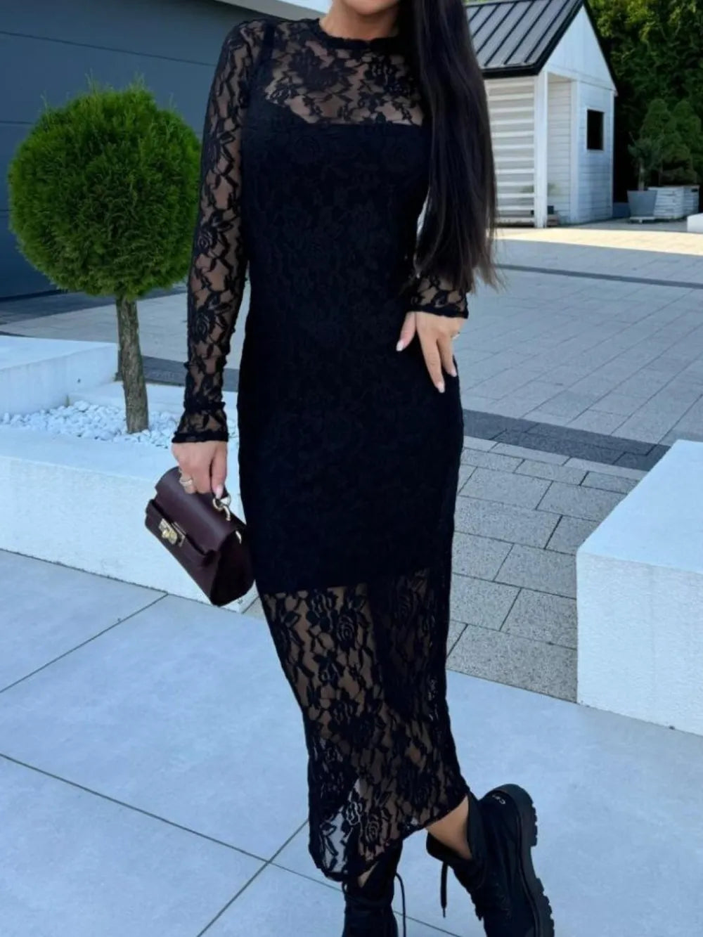 NEWYORKLISTED Valentine's Day Specials: Woman wearing a black lace dress standing outdoors on a paved area.