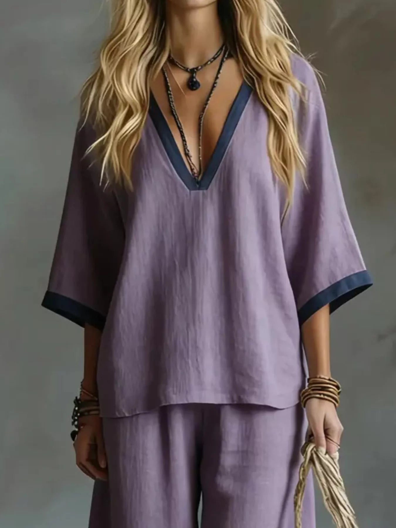 NEWYORKLISTED STYLE COLLECTION: Person wearing a purple outfit with a deep neckline against a neutral background