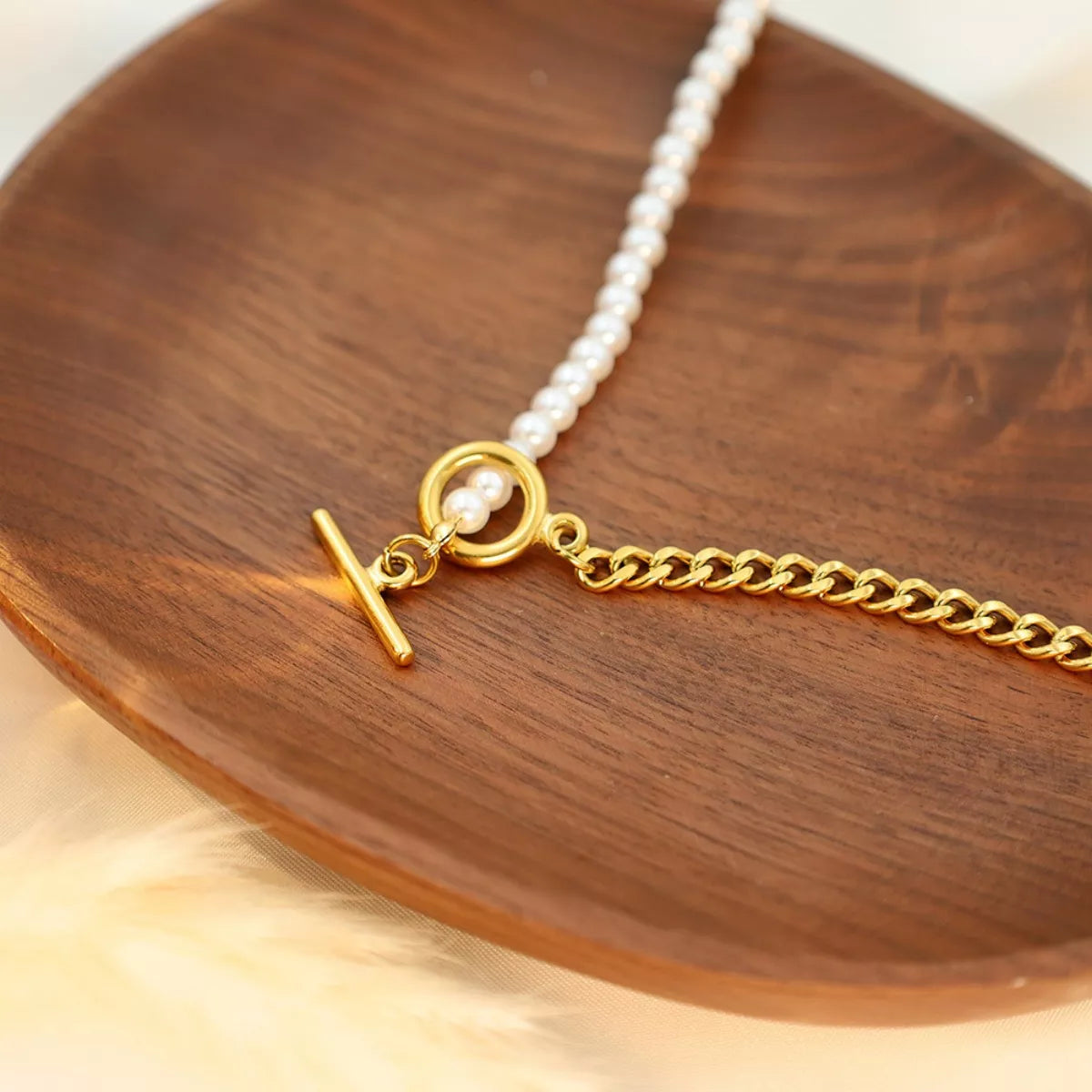 NYLD Glamour Collection by NEWYORKLISTED: Gold necklace with a pearl pendant on a wooden surface