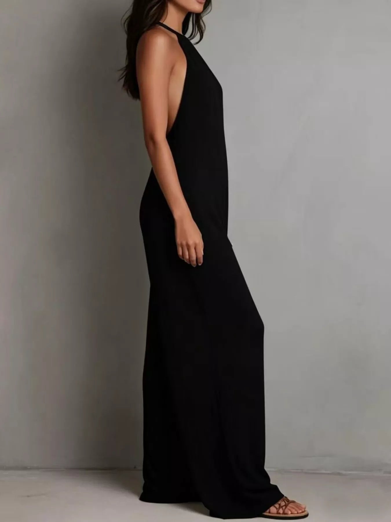 NEWYORKLISTED STYLE COLLECTION: Person wearing a black halter neck dress against a plain background