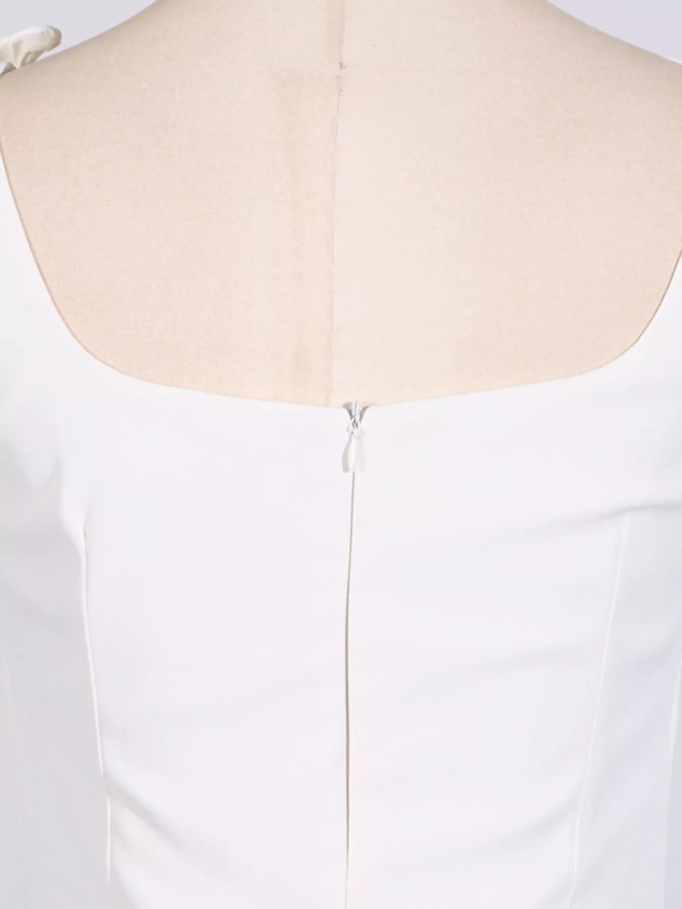 NEWYORKLISTED STYLE COLLECTION: White dress on a mannequin with a close-up of the back neckline.
