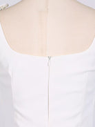 NEWYORKLISTED STYLE COLLECTION: White dress on a mannequin with a close-up of the back neckline.