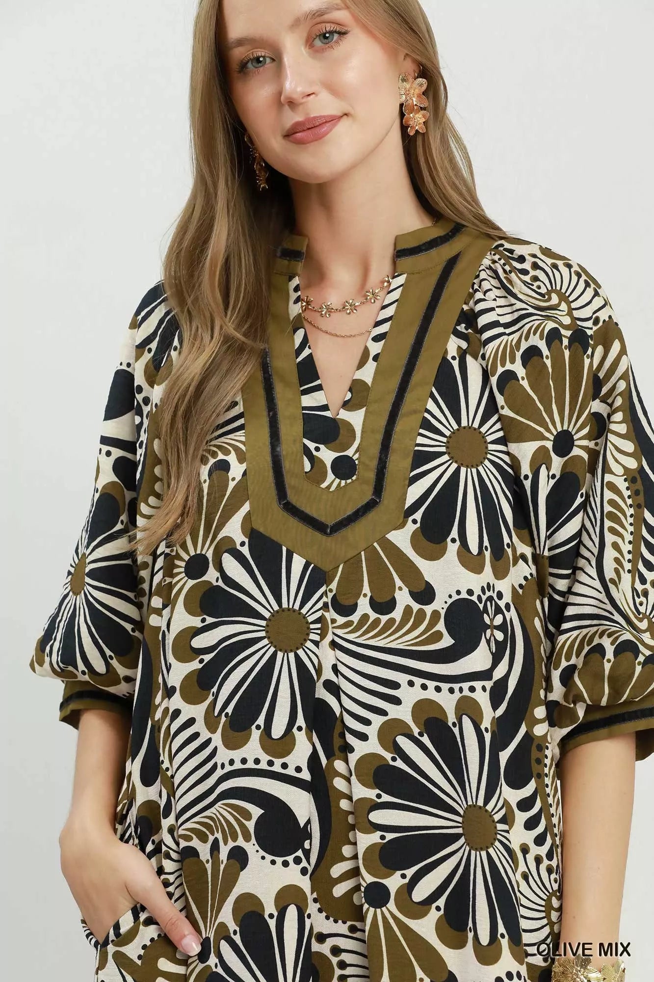 NEWYORKLISTED STYLE COLLECTION: Woman wearing a patterned dress with a neutral background