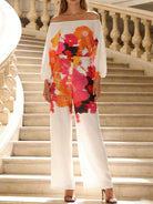 NEWYORKLSITED STYLE COLLECTION: Person wearing a colorful floral top and white pants on a staircase.